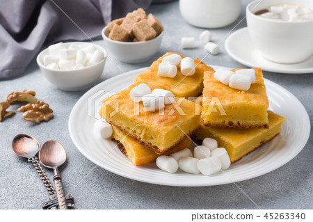 Pieces of delicious pumpkin pie with marshmallow and nuts on a plate. Pieces of delicious pumpkin pie with marshmallow and nuts on a plate. 45263340
