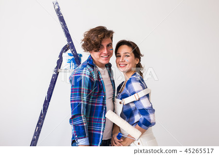 Renovation, redecoration and people concept - young family doing repair and smiling Renovation, redecoration and people concept - young family doing repair and smiling 45265517