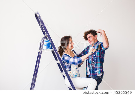 Teamwork, love couple, repair and renovation concept - young family painting wall, laughing and look 45265549