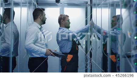 Two men performing maintenance in a data center 45266196