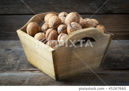 Walnuts in a wooden crate on wooden table. Walnuts in a wooden crate on wooden table. 45267660