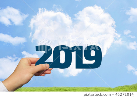 Meadow with male hand with 2019 and blue sky and heart shaped clouds Meadow with male hand with 2019 and blue sky and heart shaped clouds 45271014