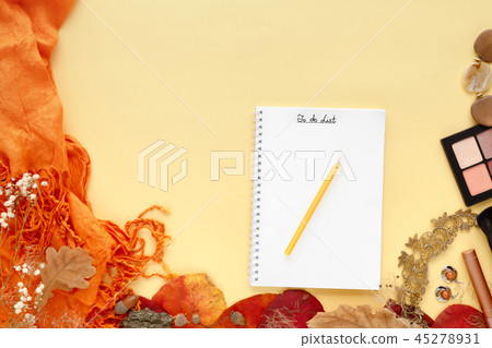 autumn leaves, scarf, paper notebook and laptop on yellow background autumn leaves, scarf, paper notebook and laptop on yellow background 45278931