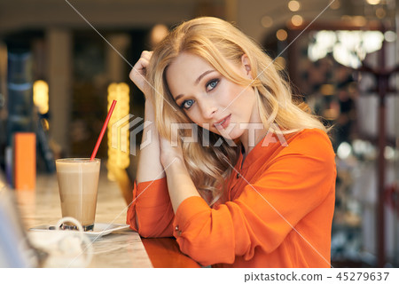 Beautiful blonde girl sitting in a cafe Beautiful blonde girl sitting in a cafe 45279637