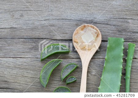 Sliced fresh Aloe Vera in wooden spoon on brown wood floor. 45281709