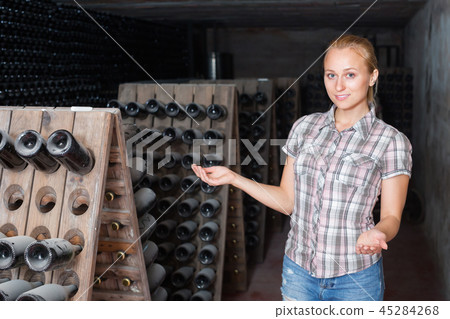 female wine maker in winery cellar. female wine maker in winery cellar. 45284268