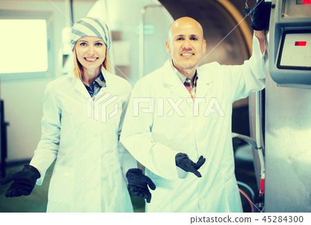 Farm staff with milk cisterns in plant. 45284300