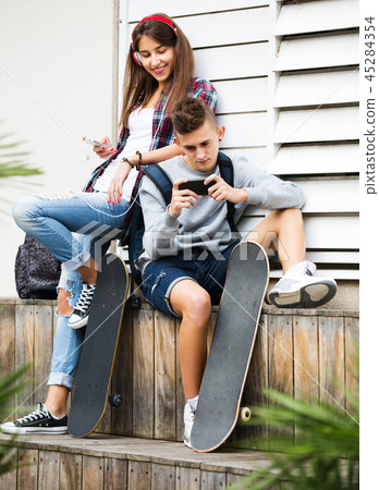 Teenage relaxing with mobile phones 45284354