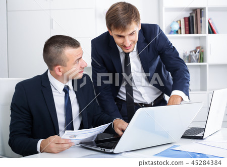 cheerful two males coworkers working in firm office cheerful two males coworkers working in firm office 45284384