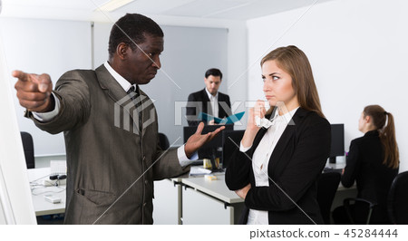Angry man boss pointinting to misses in work to female Angry man boss pointinting to misses in work to female 45284444