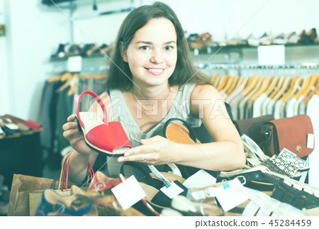 attractive female customer selecting shoes in footgear center 45284459