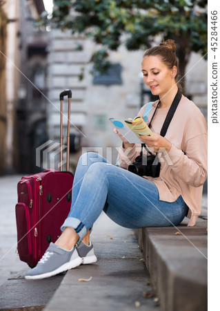 Girl having pamphlet and looking for her route in city 45284466