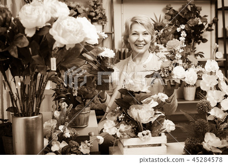 Woman selecting flowers in store 45284578
