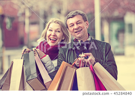 Mature spouses with shopping bags outdoor. 45284840