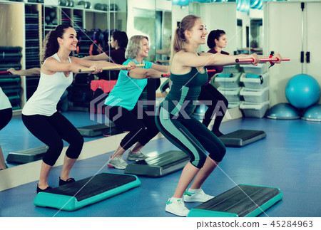 Females working out on aerobic step platform 45284963