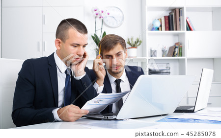 two depressed men colleagues in office . 45285078
