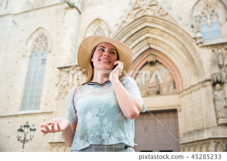 Young woman in hat talking on mobile phone at the street 45285233