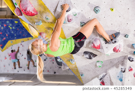 Woman training at bouldering gym Woman training at bouldering gym 45285349