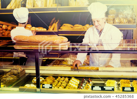 two bakers at the counter at bakery. 45285368
