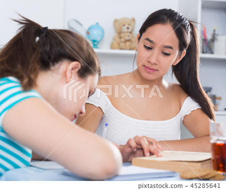 Teens girls doing homework and discussing 45285641