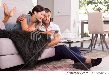 Happy woman with boyfriend using mobile phone 45285857