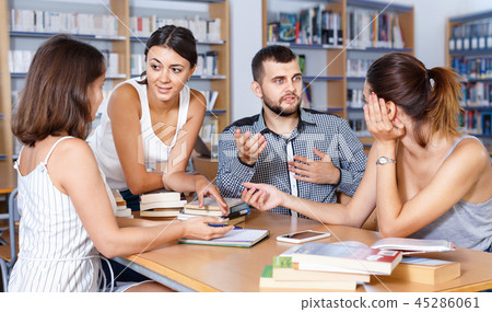 Happy young university students preparing for exam together, brainstorming in library 45286061