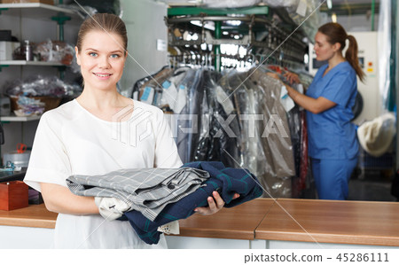 Happy woman at dry cleaning 45286111