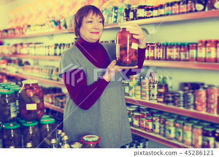 female consumer holding glass jar of tomatoes female consumer holding glass jar of tomatoes 45286121