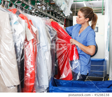 Worker checking clean clothes in laundry+ Worker checking clean clothes in laundry+ 45286138