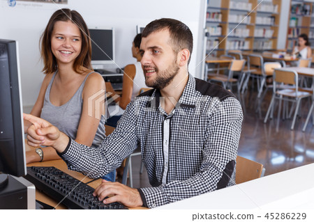 Young people using pc in library 45286229