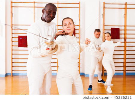 fencer practicing movements with african american trainer fencer practicing movements with african american trainer 45286231