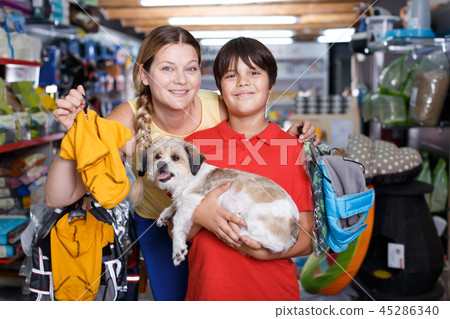Female customer with son buying dog clothes Female customer with son buying dog clothes 45286340