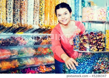 Girl choosing sweets in shop Girl choosing sweets in shop 45286347