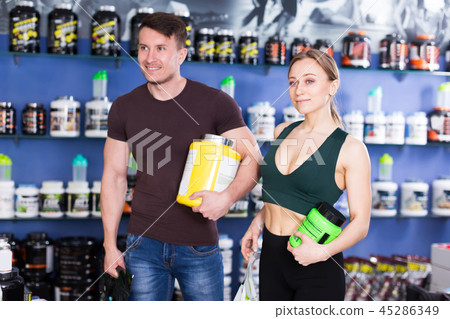 couple with purchases in shop of sports nutrition couple with purchases in shop of sports nutrition 45286349