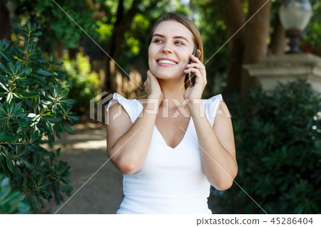Woman using phone in park Woman using phone in park 45286404