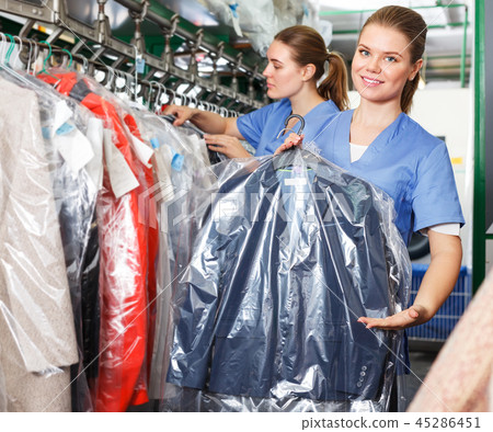 Worker of laundry demonstrating clean garment Worker of laundry demonstrating clean garment 45286451