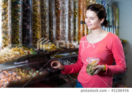 Happy girl is choosing candies Happy girl is choosing candies 45286456