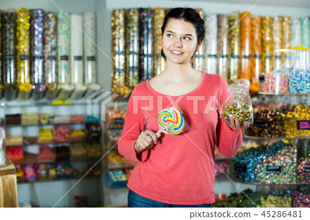 Girl chooses caramels and candies Girl chooses caramels and candies 45286481