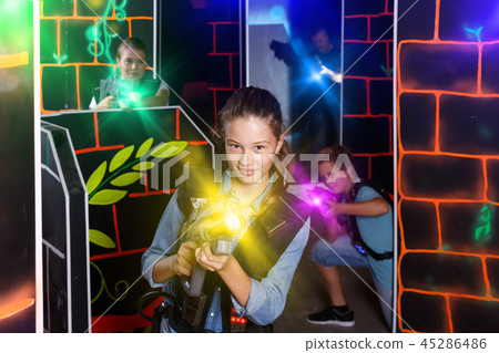 Positive girl aiming laser gun at other players Positive girl aiming laser gun at other players 45286486