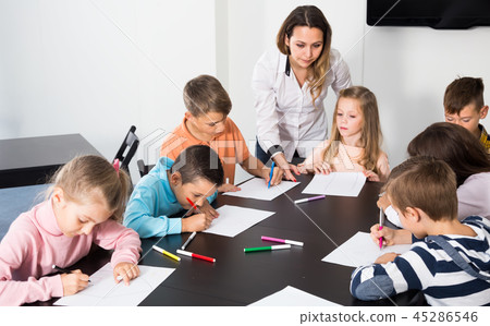 joyous little children with teacher drawing in classroom joyous little children with teacher drawing in classroom 45286546
