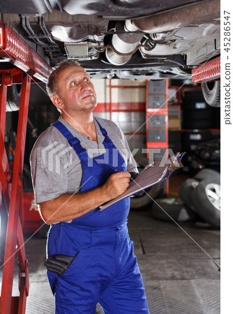 Male mechanic taking notes about car repair 45286547
