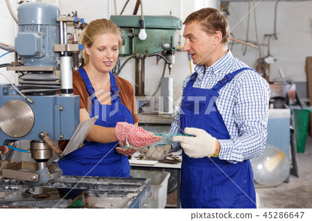Woman with male colleague working on glass drilling machine Woman with male colleague working on glass drilling machine 45286647