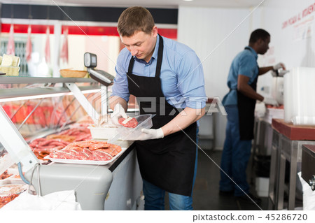 Butchers preparing meat products for sale Butchers preparing meat products for sale 45286720