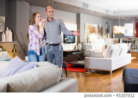 Positive couple choosing furniture for apartment 45287012