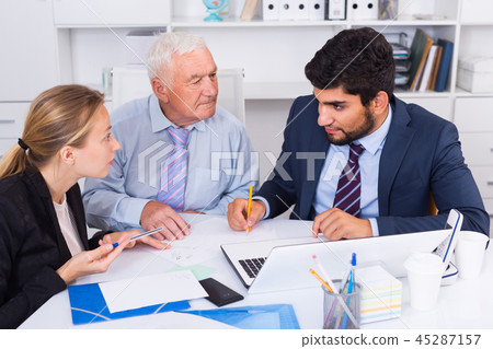 Office workers are writing financial reports and discussing with mature boss 45287157