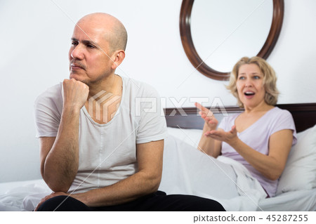 Mature couple having quarrel in bedroom. 45287255