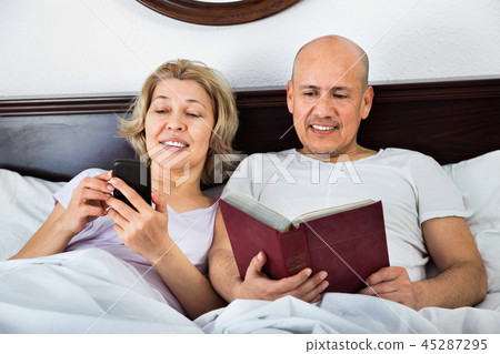 Smiling mature couple together social networking Smiling mature couple together social networking 45287295