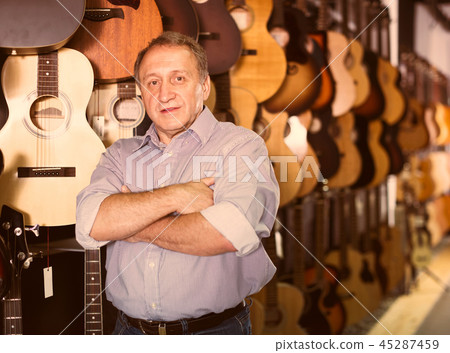 Mature man choosing acoustic guitar Mature man choosing acoustic guitar 45287459