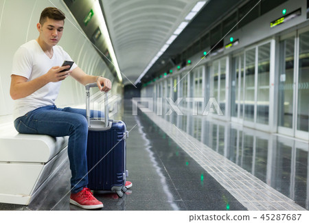 Man traveling on subway and using smartphone Man traveling on subway and using smartphone 45287687