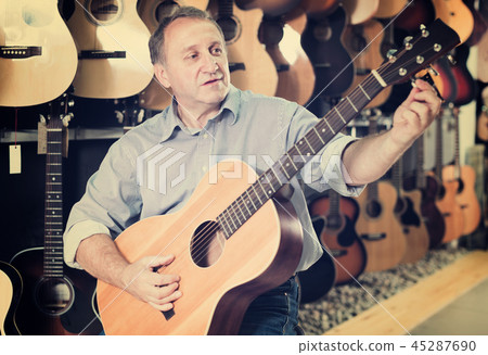 Man playing on acoustic guitar Man playing on acoustic guitar 45287690